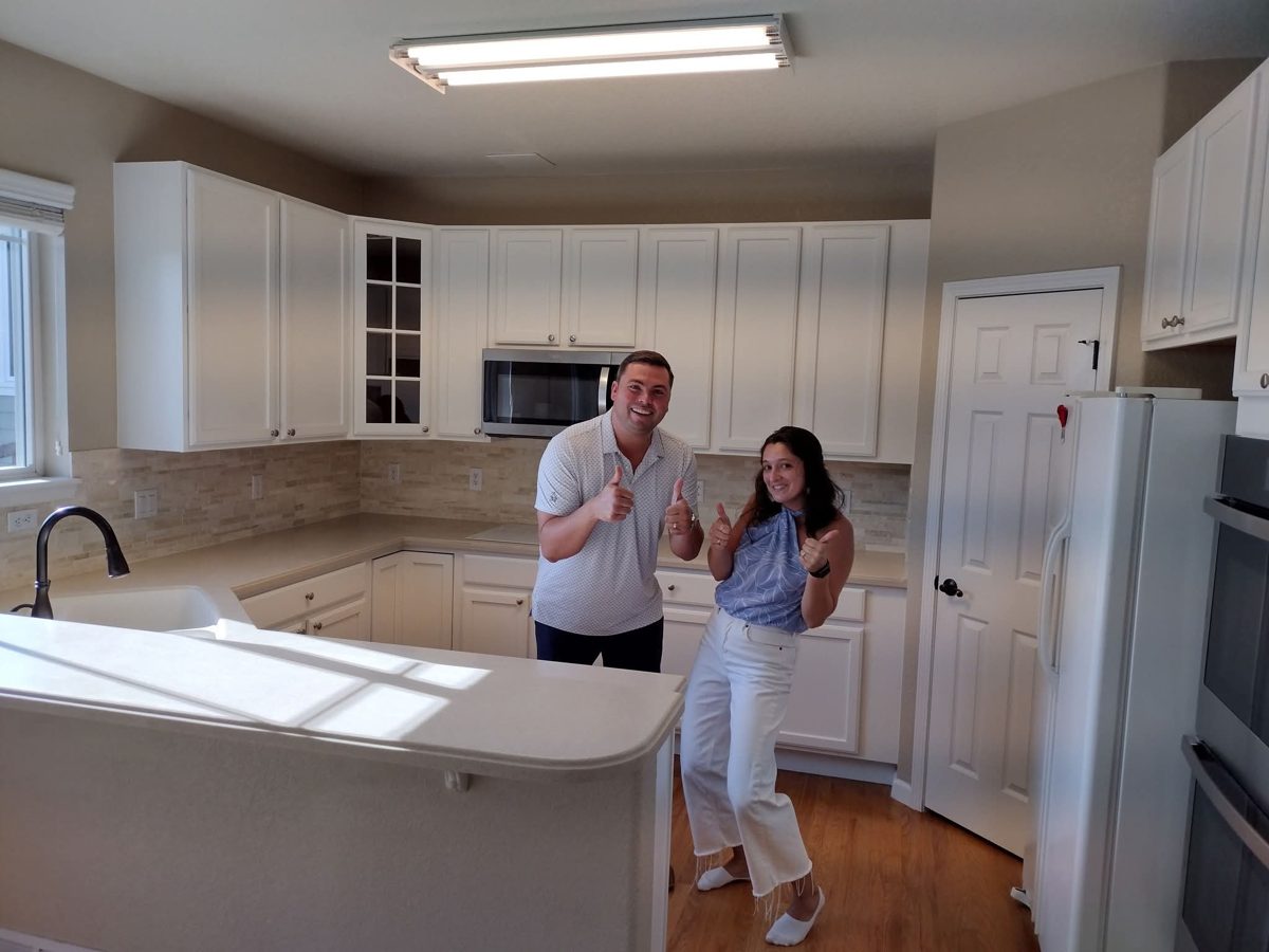 Happy clients giving a thumbs-up in their finished kitchen