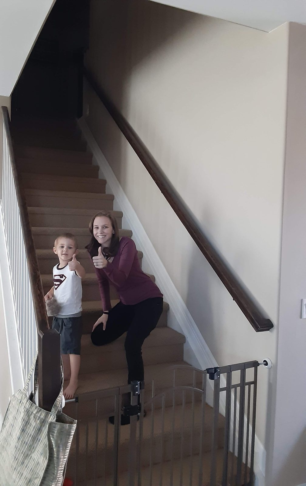 Mother and young son giving a thumbs-up on their freshly painted staircase